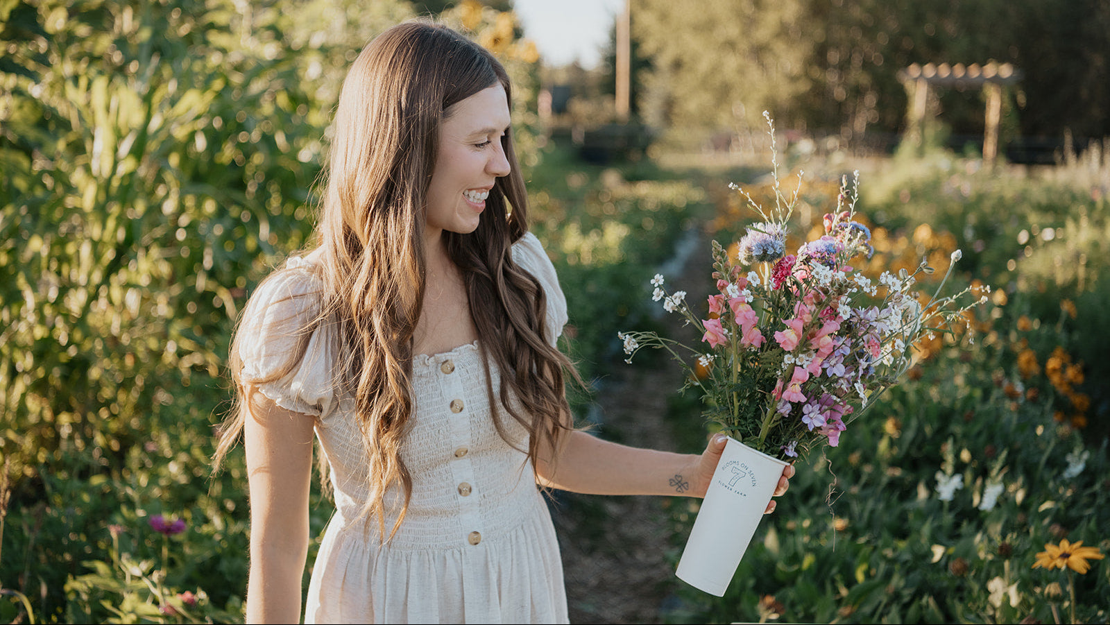 Woman holding a bouquet of flowers in a garden